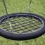 Single Swing (BNS 90cm) balançoire circulaire noire avec design en filet sur une pelouse verte