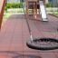 Single Swing (BNS 90cm) balançoire ronde en filet sur une aire de jeux avec revêtement de sécurité et structure d'escalade