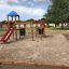 Aire de jeux pour enfants avec cabane d’escalade et toboggan.