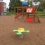 Aire de jeux pour enfants avec structure Climbing Booth et cheval à ressort sur sol sablonneux.