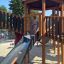 Équipement de aire de jeux Citadel castle with slide pour enfants dans un parc.