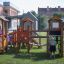 Alpha playhouse with slide dans une aire de jeux avec des enfants qui jouent