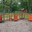 Équipement de terrain de jeu extérieur Trixie avec plusieurs stations d’activité dans un parc.