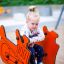 Enfant jouant sur Bulldozer rocking dans une aire de jeux.