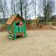 Des enfants jouent sur Britta's Playhouse structure de jeu en bois avec mur d'escalade et toboggan.