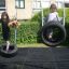 Des enfants jouent sur un Double Tyre double swing dans un jardin.