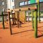 Spillikins wooden playhouse sur une aire de jeux moderne avec cordes d'escalade et structures en bois.