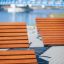 Montpellier Deck Chair d’extérieur au bord de la rivière avec un pont bleu en arrière-plan.