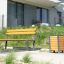 Un banc en bois moderne avec une poubelle à côté dans un quartier résidentiel.