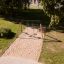 Double Safety Seat double swing sur une aire de jeux avec terrain sablonneux.