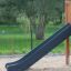 Toboggan de l'ensemble de terrain de jeu Romping Corner Nature dans une aire de jeu sablonneuse avec de la verdure en arrière-plan