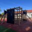 Climbing Booth Nature, wooden playhouse avec murs d'escalade et toboggan dans un terrain de jeu.