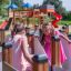 Deux filles jouent dans la structure de labyrinthe de l’aire de jeux Ariadne avec un toboggan en arrière-plan.