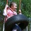 Enfant profitant du Wooden Tire double swing dans un parc