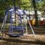 Wheelchair Swing dans une aire de jeux parmi les arbres