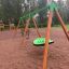 Vert Swing Seat GBNS sur une structure de jeu en bois dans un parc.