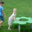 Des enfants jouent autour de Clover Play Table dans un parc.