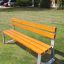 Tallin Bench w/ Backrest dans une zone de parc herbeuse.