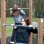 Femmes faisant de l’exercice sur des barres de traction dans une salle de sport en plein air.