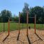 Barres de traction extérieures dans un terrain de jeu avec un revêtement en copeaux de bois.