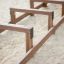 Structure de jeu en bois Balance sur une aire de jeux sablonneuse.