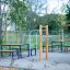 Station de fitness extérieure Bars II avec des bancs autour dans un parc.
