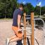 Homme utilisant l’équipement d’entraînement extérieur Bars II pour un exercice du haut du corps.