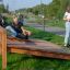 Enfants jouant sur un banc à abdominaux dans un parc extérieur.