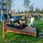 Enfants faisant de l’exercice sur un banc à abdominaux dans un parc.