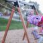 Des enfants jouent sur Swing Frame 1(BNS) +1 (double swing) dans une aire de jeux.