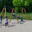 Des enfants jouent sur Swing Frame 1(BNS) +1 (double swing) dans une aire de jeux