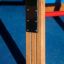 Vertical wooden ladder avec supports métalliques dans une aire de jeux.