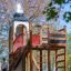 Alcazar playground castle avec structure en bois et toboggan dans un cadre de parc