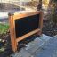 Extérieur 'Blackboard' avec cadre en bois placé dans un parc.