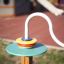 L’équipement de jeu coloré Rings de LarsLaj est installé sur un poteau en bois.