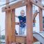 Enfant jouant sur la structure de jeu en bois Etna avec un toboggan.
