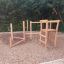 Caucasus wooden playhouse sur une aire de jeux en gravier.