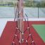 Ural climbing net dans une aire de jeux avec des supports en bois et un revêtement de sécurité rouge.