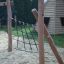 Structure en bois avec filet d’escalade dans une aire de jeux, Ural climbing net.