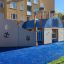 Bateau à vapeur de aire de jeux avec toboggan sur une surface en caoutchouc bleue dans un quartier résidentiel.