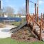 Structure de jeu Hekla avec marches en bois et toboggan dans un parc