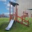 Toboggan de jeu en bois Hekla avec escalier d’escalade sur une colline herbeuse