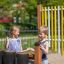 Des enfants jouent avec des tambours musicaux d’extérieur dans une aire de jeux.
