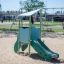Mars playhouse with slide dans une aire de jeux sablonneuse.