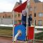 Enfant jouant sur Neptune single playhouse avec toit rouge et plateforme jaune.