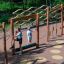 Enfants jouant sur un équipement de jeu extérieur en bois Trim Trail Nature II dans un parc