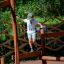 Enfant en équilibre sur une structure de jeu en bois Trim Trail Nature II dans une aire de jeux