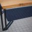 Thor table avec pieds en métal sur une surface extérieure carrelée.
