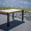 Thor table avec pieds en métal et plateau en bois installé au bord de la rivière.