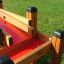 Tables d’eau en bois et rouges Sand & Water Play 2 dans une zone extérieure herbeuse